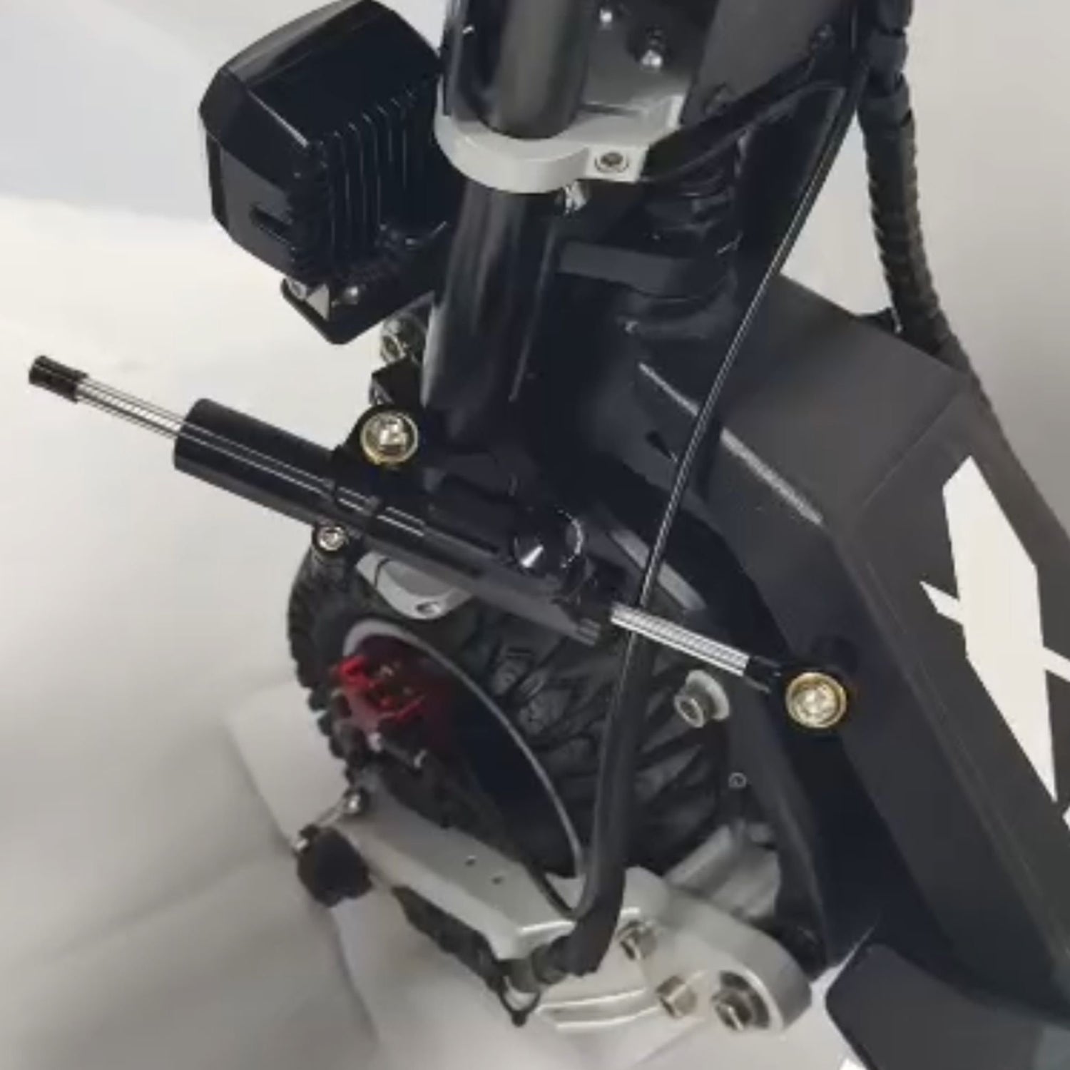 Close-up of a black Rooder steering damper installed on the front fork of a Glidezone GD83 electric scooter.