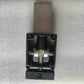 Underside view of the automatic kickstand replacement part for Rooder X60 Plus electric scooter, displaying the black plastic housing, hinge pin mechanism with grease, and a bottom cross-head screw.